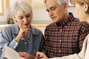 how to make a will near syracuse ny image of elderly couple looking over paperwork with a lawyer