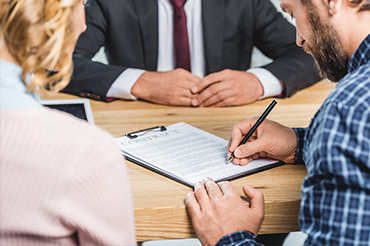 family court lawyers near syracuse ny image of man signing contract in front of lawyer and wife