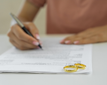 uncontested divorce lawyer near syracuse ny rings on table signing divorce papers